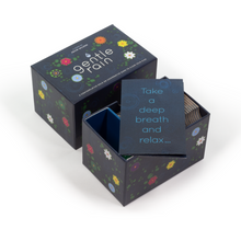 Load image into Gallery viewer, A Gentle Rain box opened with the rulebook that says "Take a deep breath and relax..." on the front